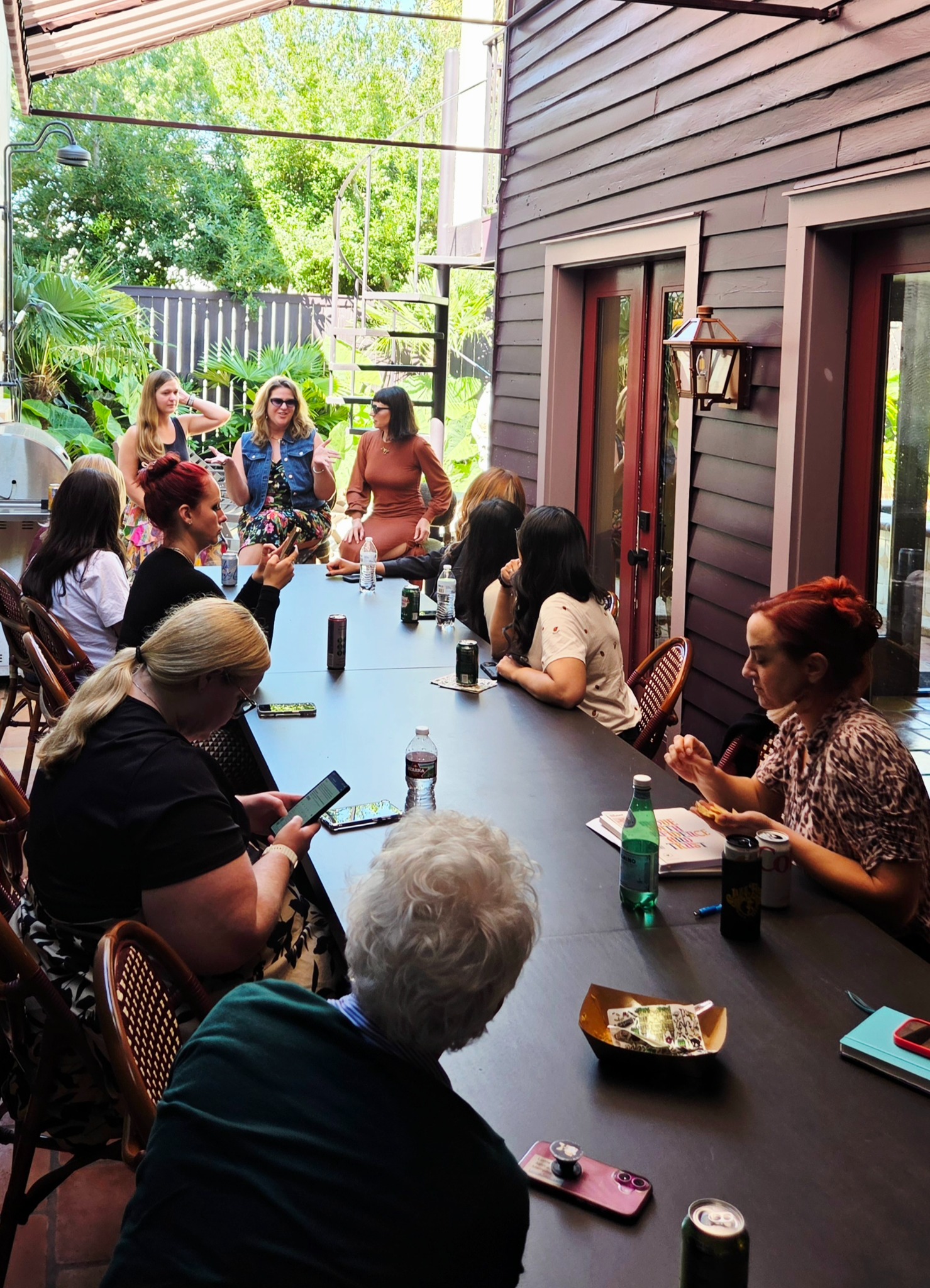 A small group gathered around a patio table for a Women in Sales retreat discussion.